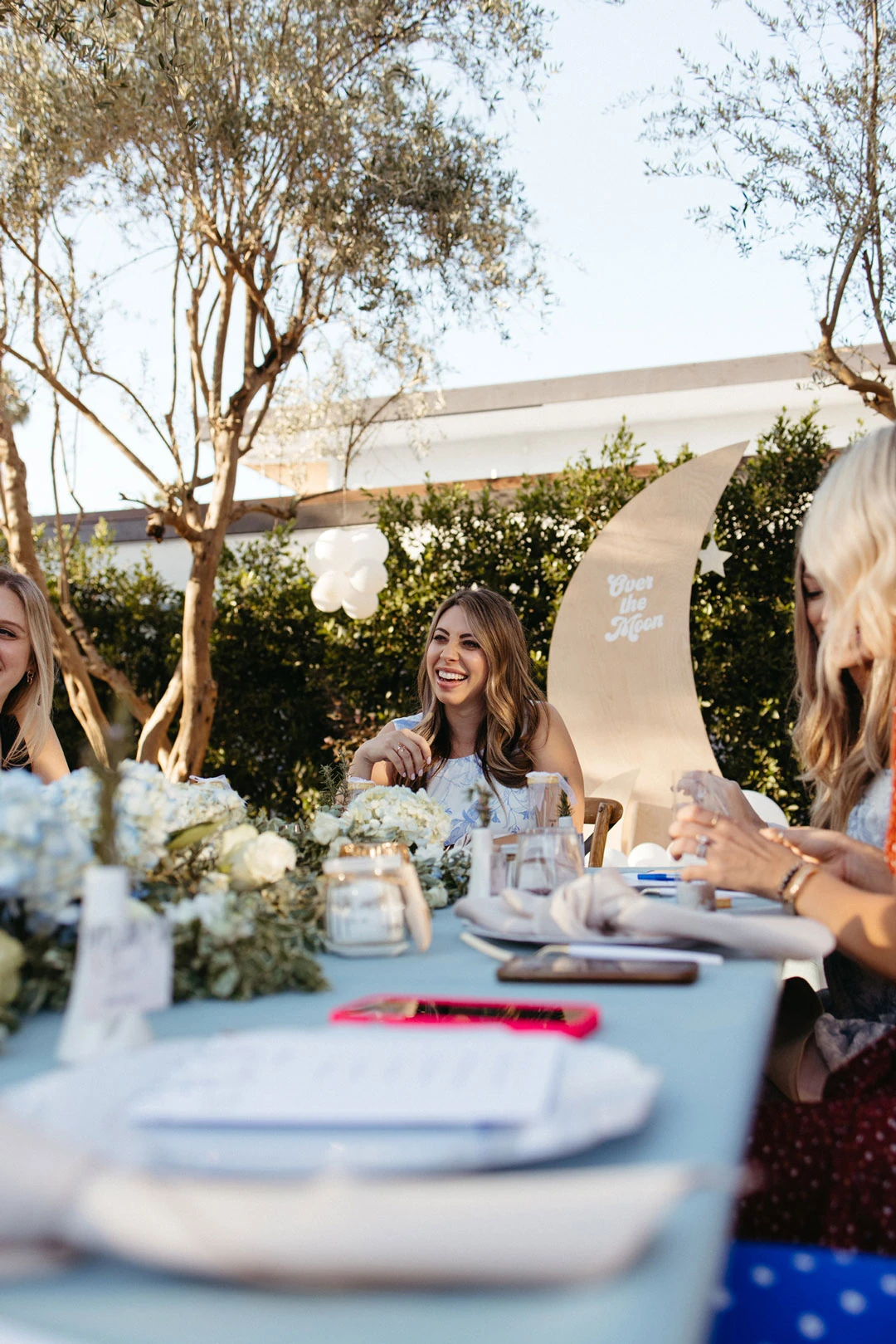 Guest sits at a blue-covered outdoor reception table.