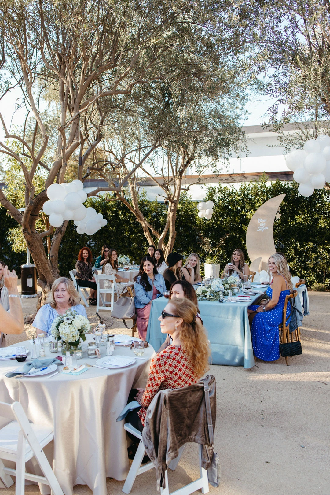 Guests sit around an outdoor reception table.
