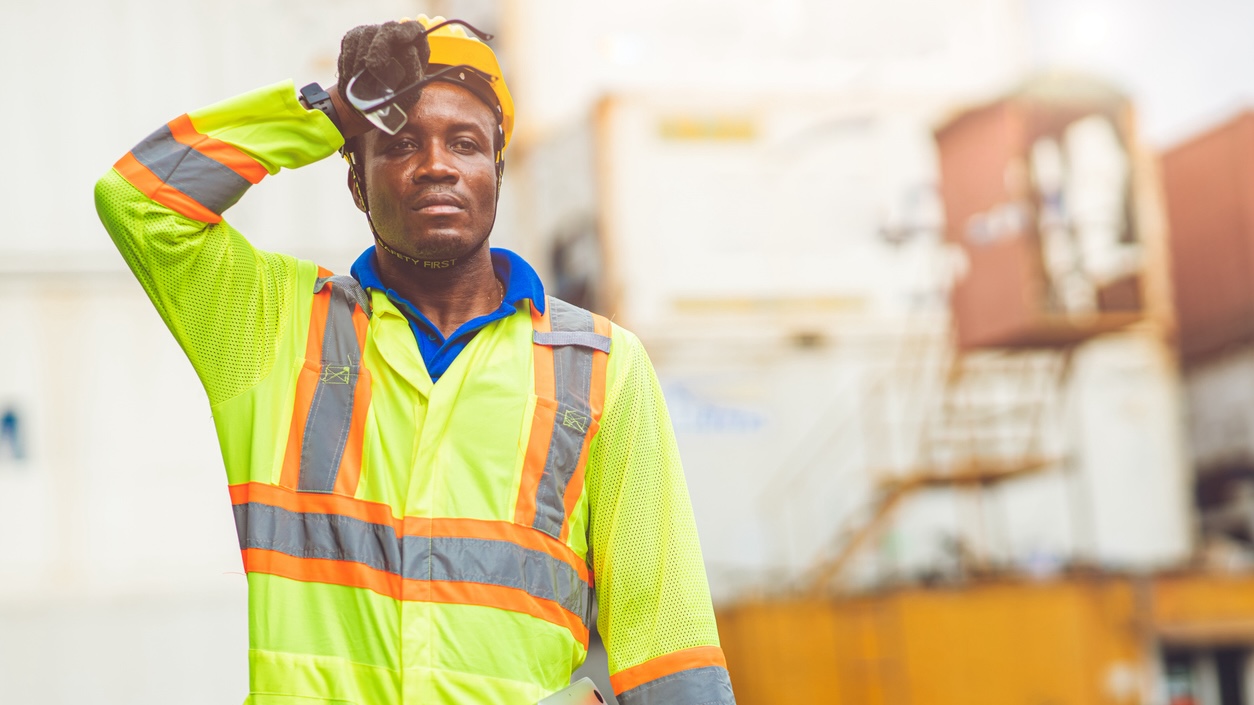 A construction worker wipes sweat from his forehead