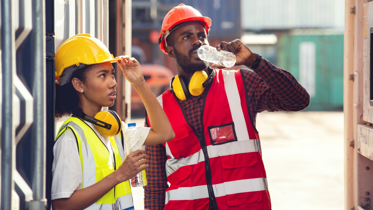 Workers drink from water bottles during a rest break.