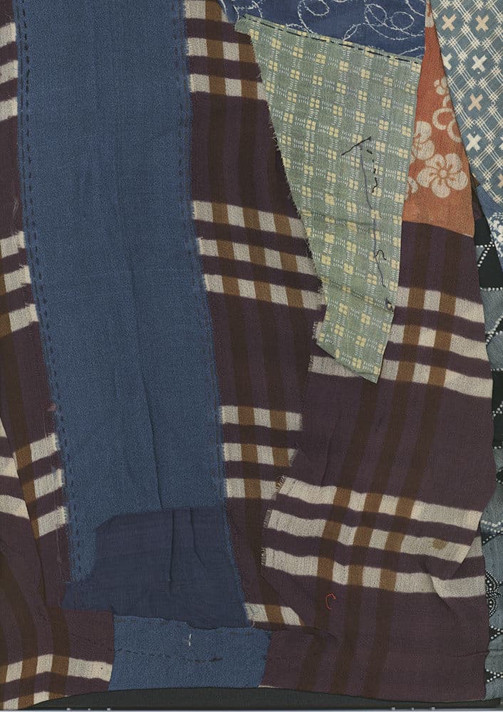 Patchwork quilt with plaid patterns in blue, brown, and green fabrics