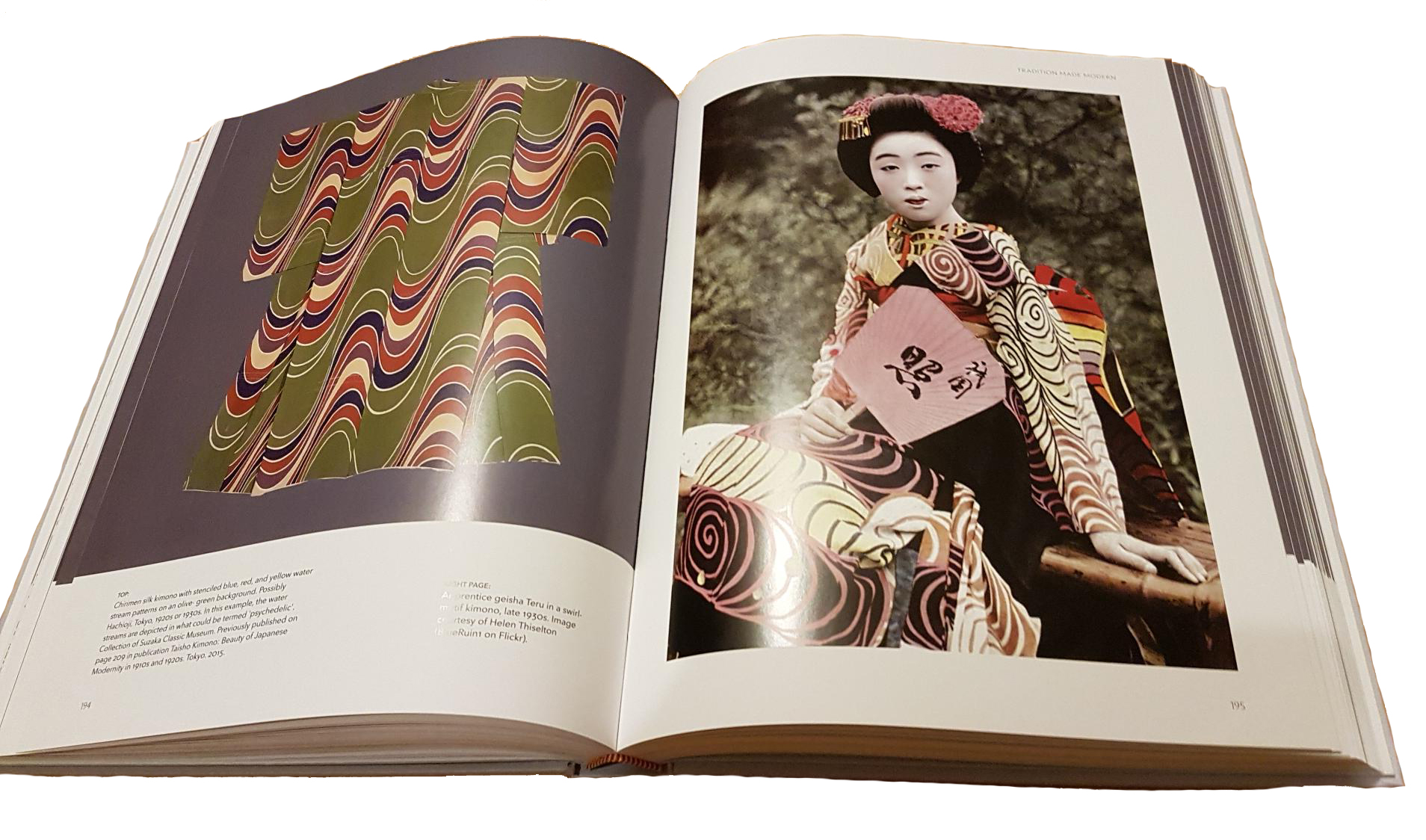 Traditional Japanese geisha in ornate kimono with wavy pattern book spread