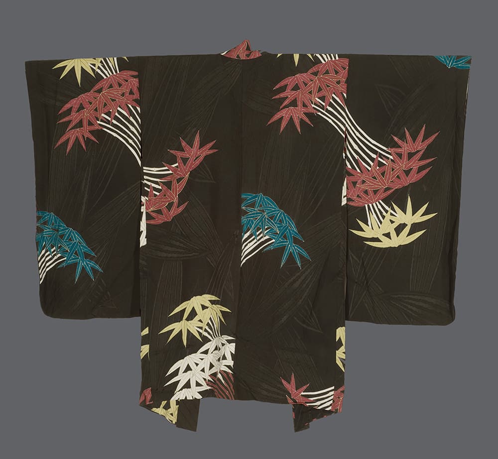 Traditional Japanese kimono with colorful maple leaf pattern on dark background