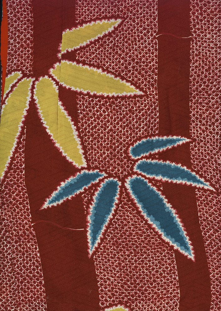 Stylized leaves in yellow and blue on a textured red background