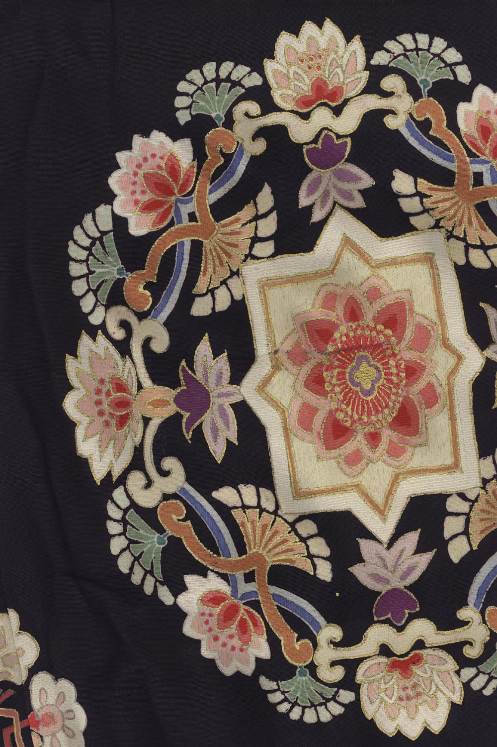 Intricate floral embroidery with ornate lotus and star-shaped design on black fabric