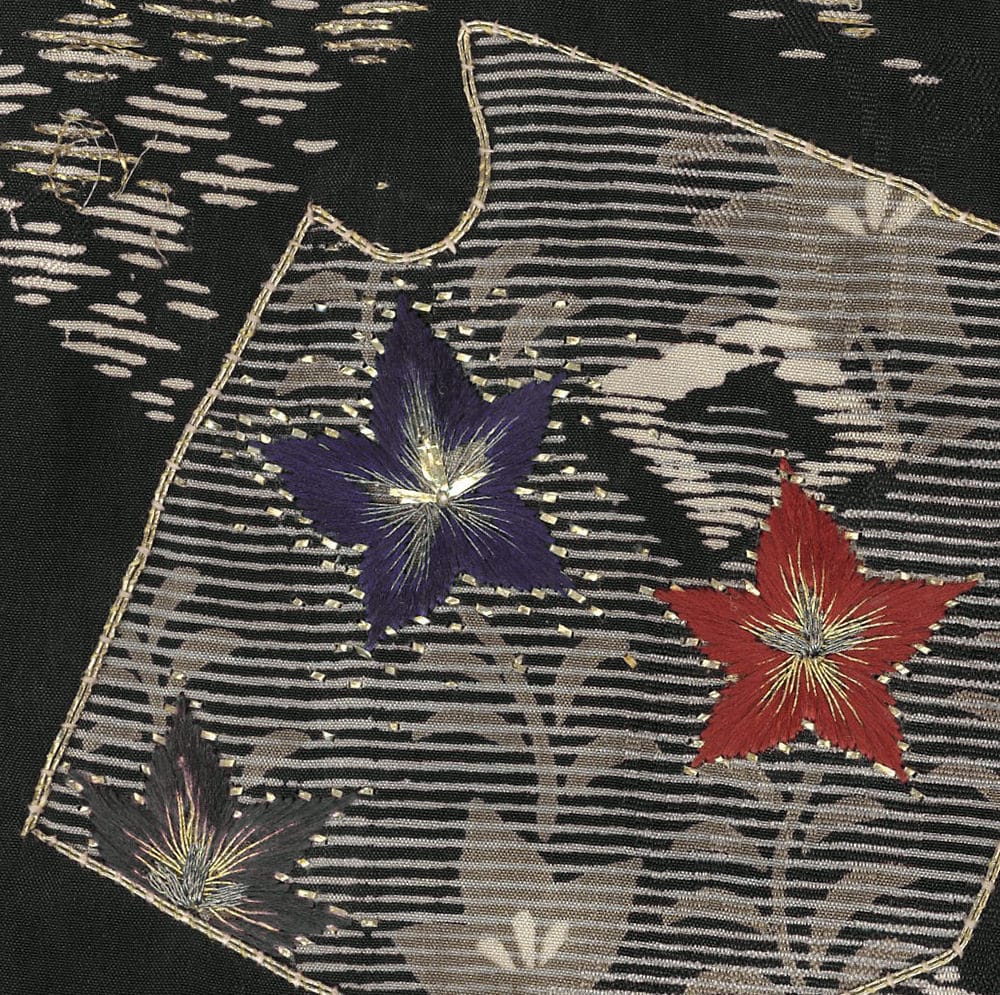 Embroidered fabric with colorful star-shaped flowers on textured background