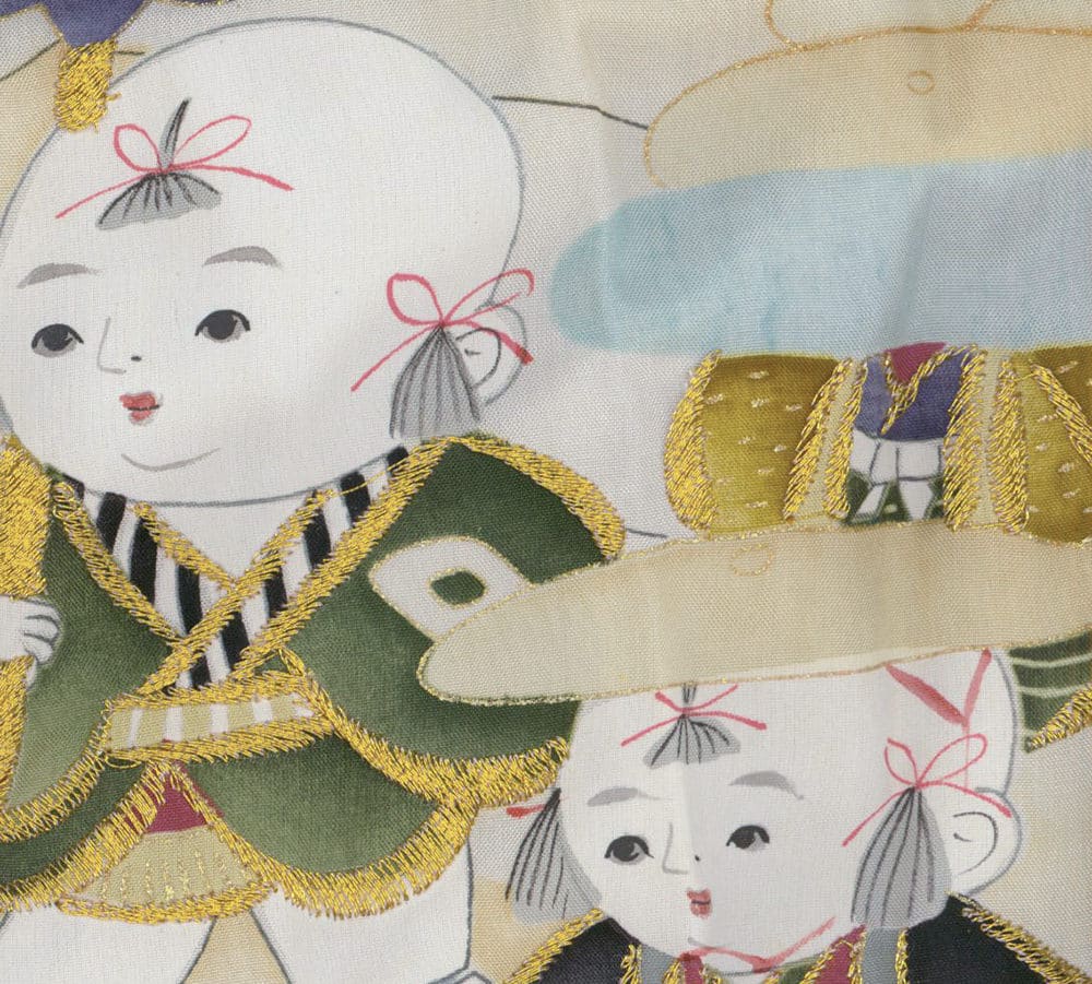 Traditional Japanese textile with embroidered dolls in golden and green colors