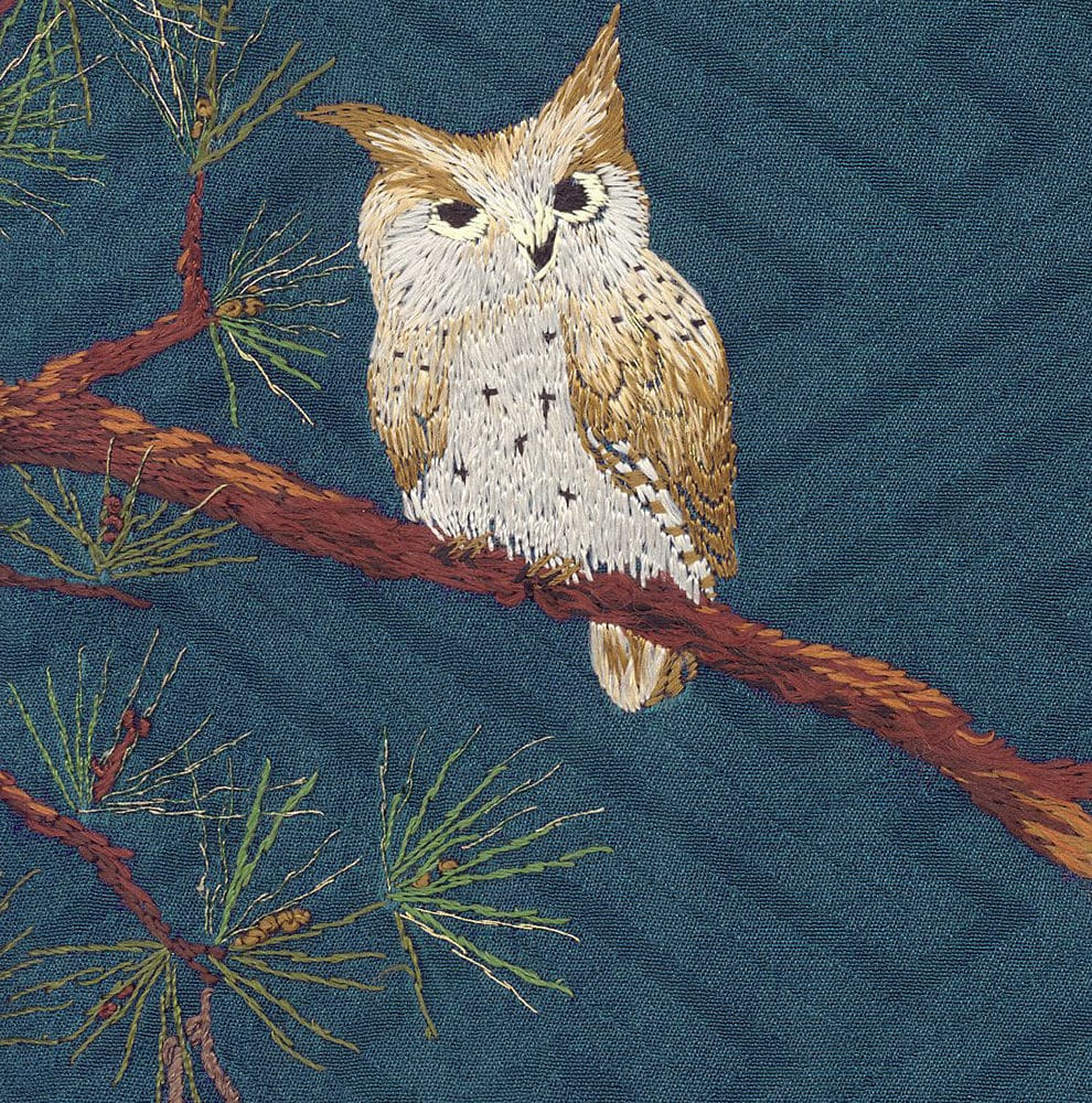 Embroidered owl perched on branch with pine needles, detailed textile art