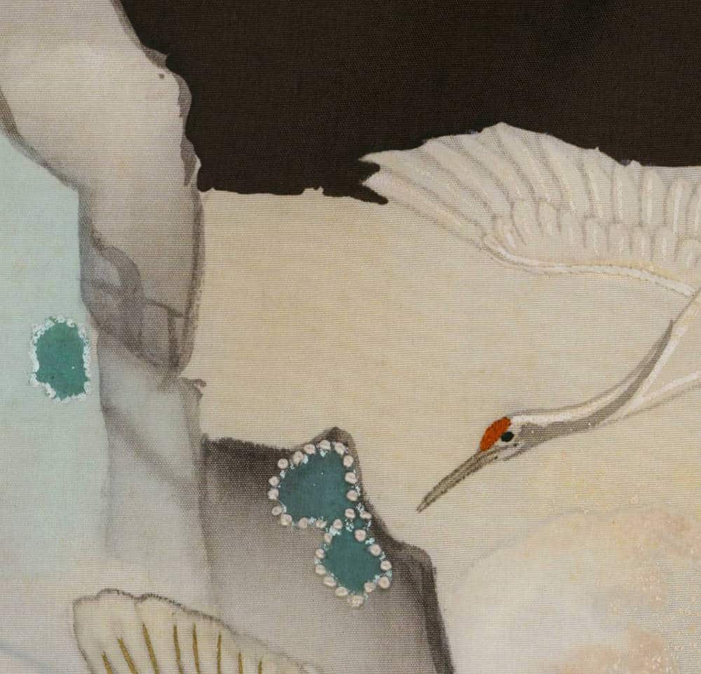 Delicate bird with pearl and teal jewelry on soft, muted background