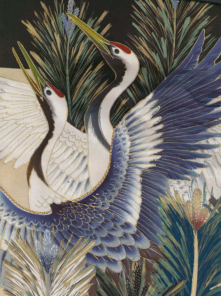 Two elegant cranes with blue and white feathers among pine branches