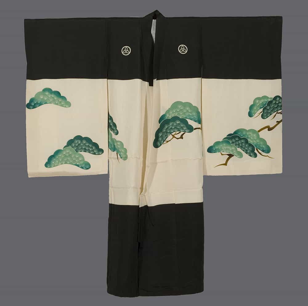 Black and white kimono with green pine tree design on cream background