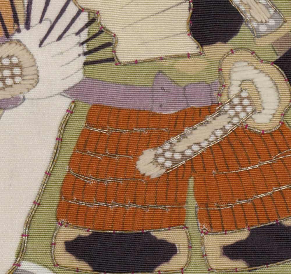 Detailed embroidered textile with orange, green, and purple geometric patterns