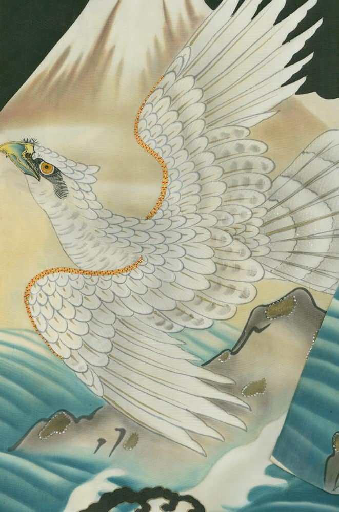 Elegant white bird with spread wings flying over blue-green waves