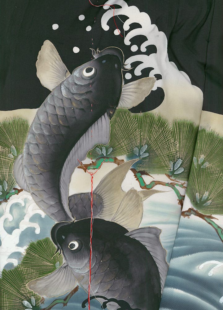 Two koi fish swimming near pine branches and water waves