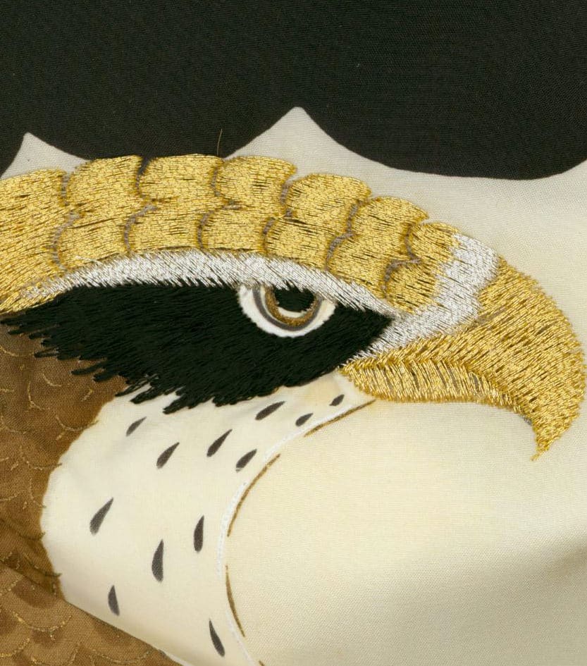 Embroidered golden and white eagle eye with detailed stitching