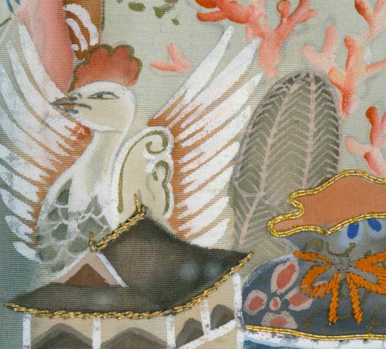 Decorative textile with stylized white bird and ornate gold embroidery