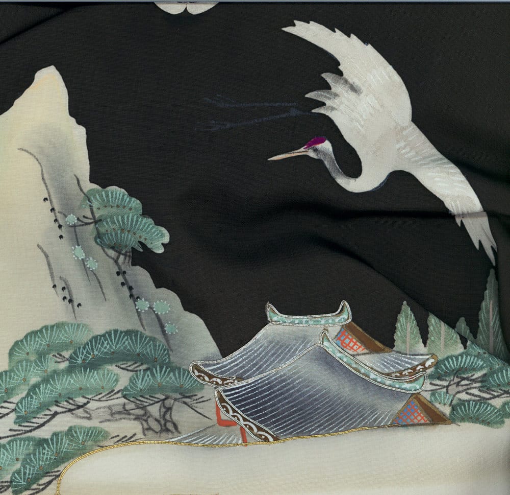 White crane flying over traditional Japanese building and pine trees