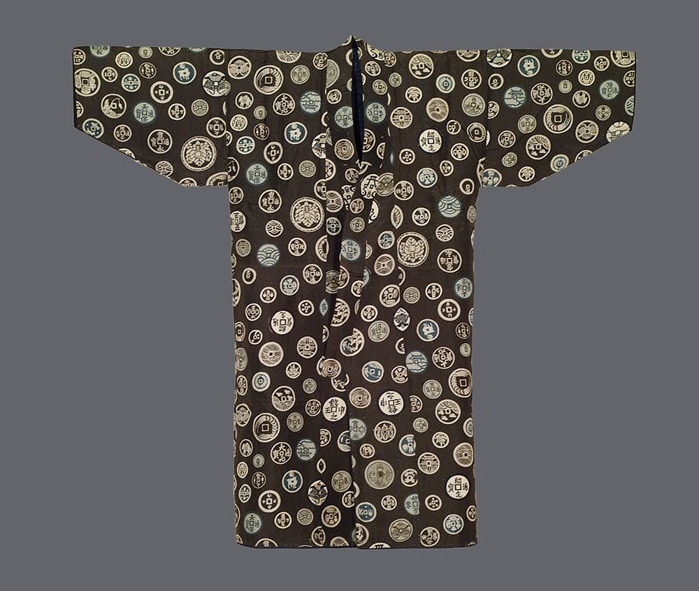 Japanese kimono with intricate pattern of vintage coins on dark background