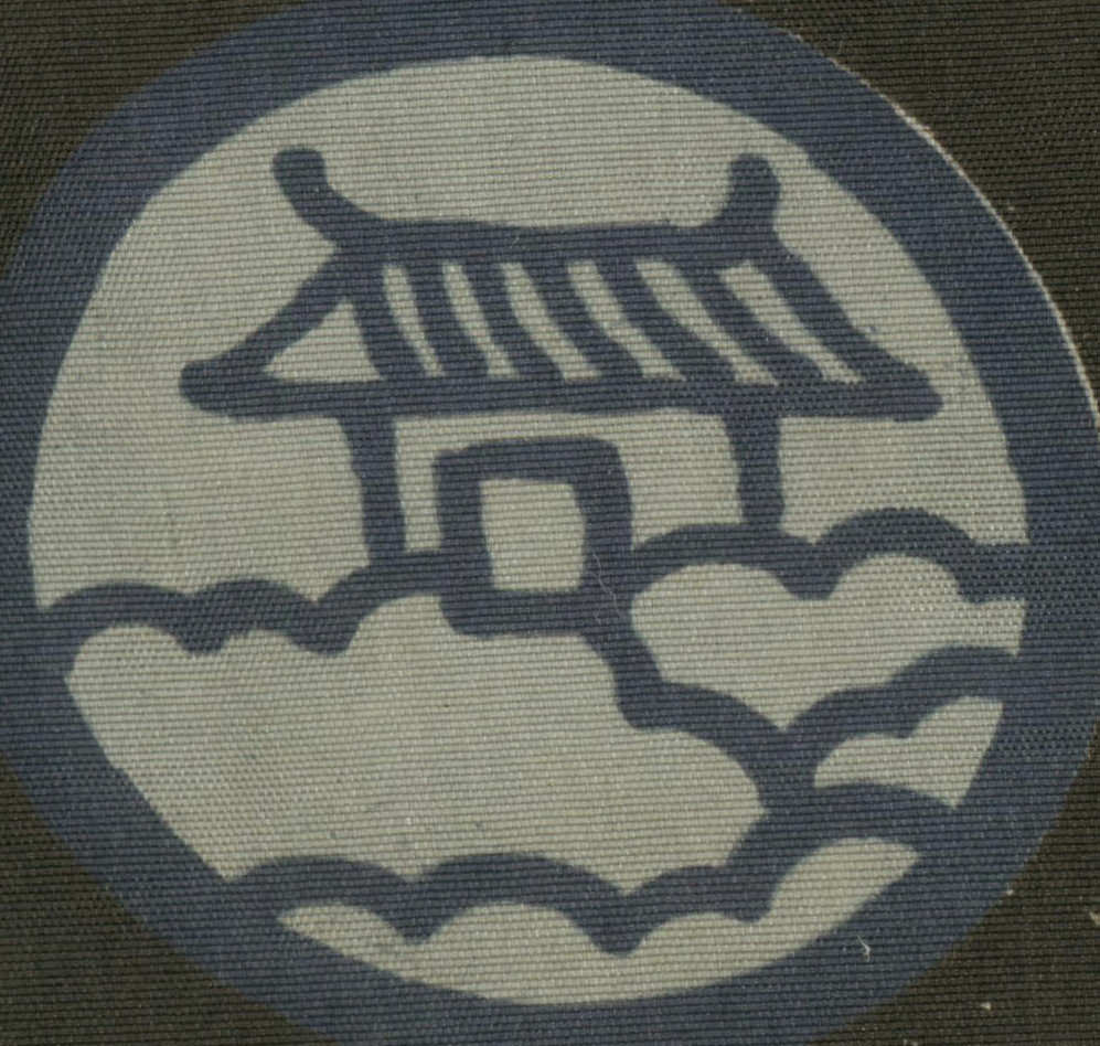 Stylized symbol or character on textured fabric in blue and gray tones