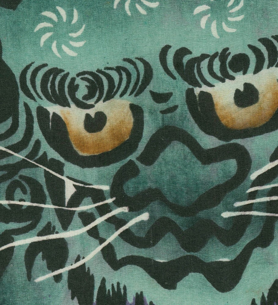 Abstract textile with stylized green and yellow circular eye-like shapes