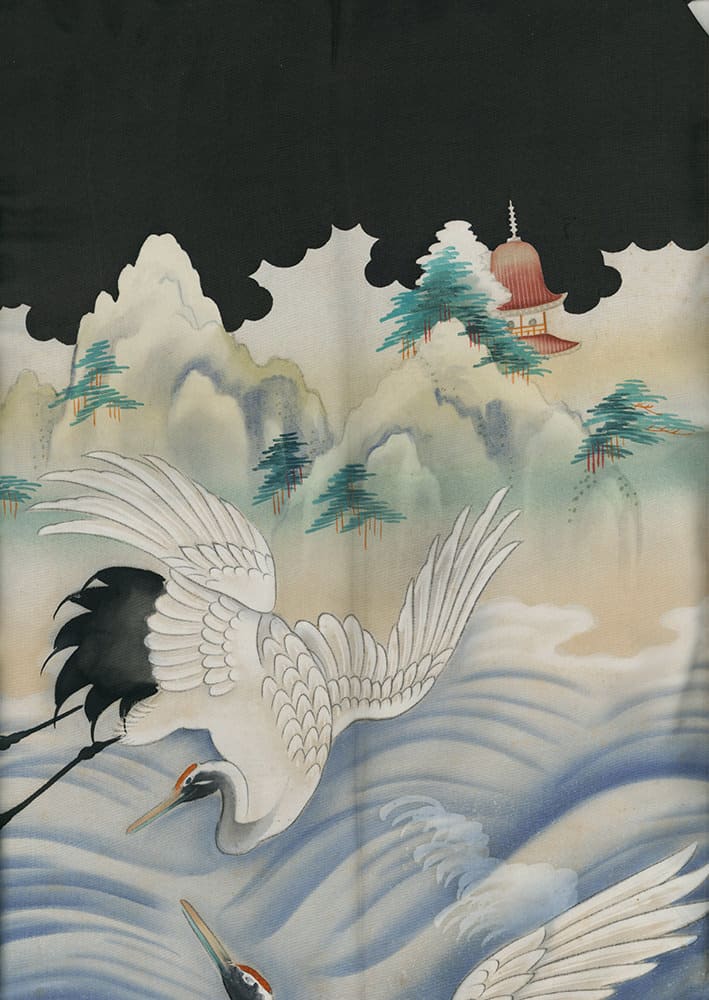 Cranes flying near misty mountains with a small temple in distance