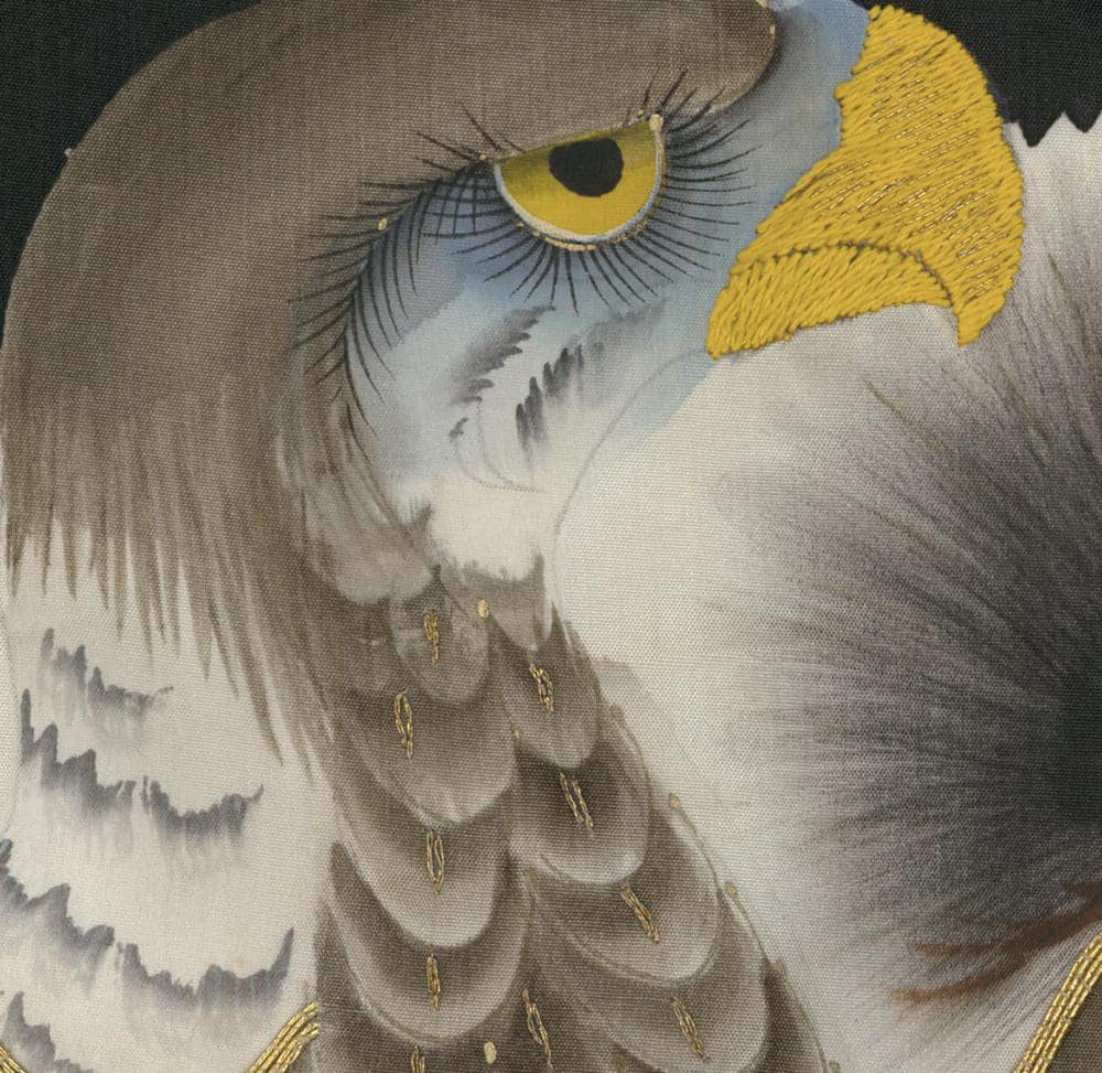 Close-up of an eagle with piercing yellow eye and detailed feather texture