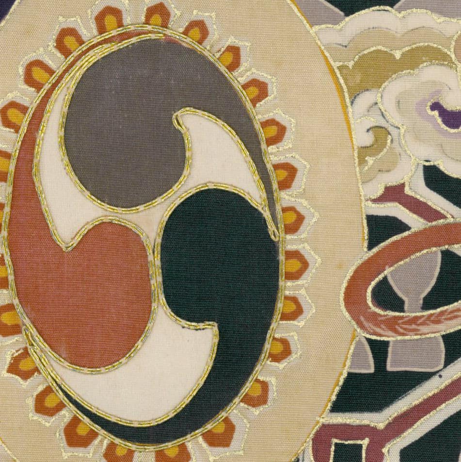 Ornate Japanese textile with swirling comma-like shape and golden outlines