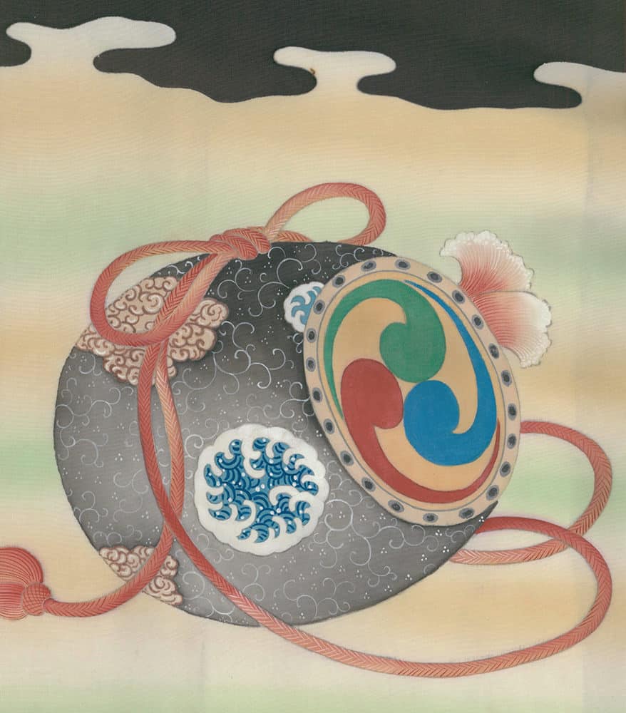 Japanese decorative drum with intricate patterns and red ribbons against soft background