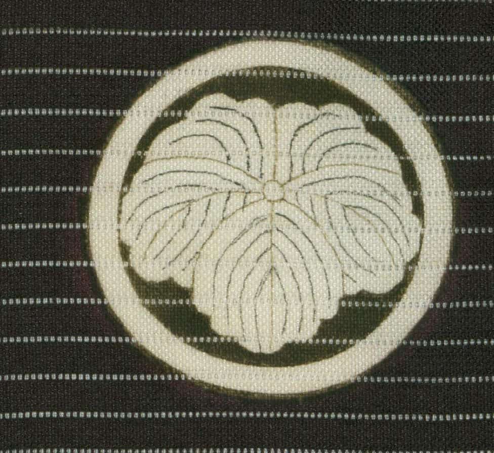 Symmetrical botanical design of stylized flower or leaf on textured fabric