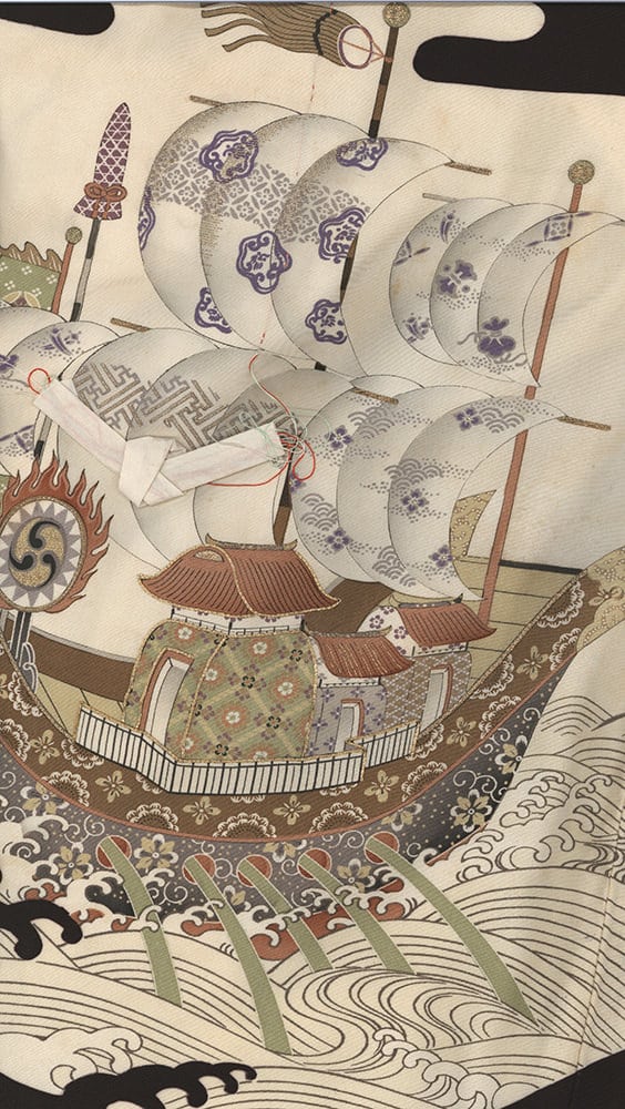 Traditional Japanese sailing ship with ornate sails navigating stormy waves