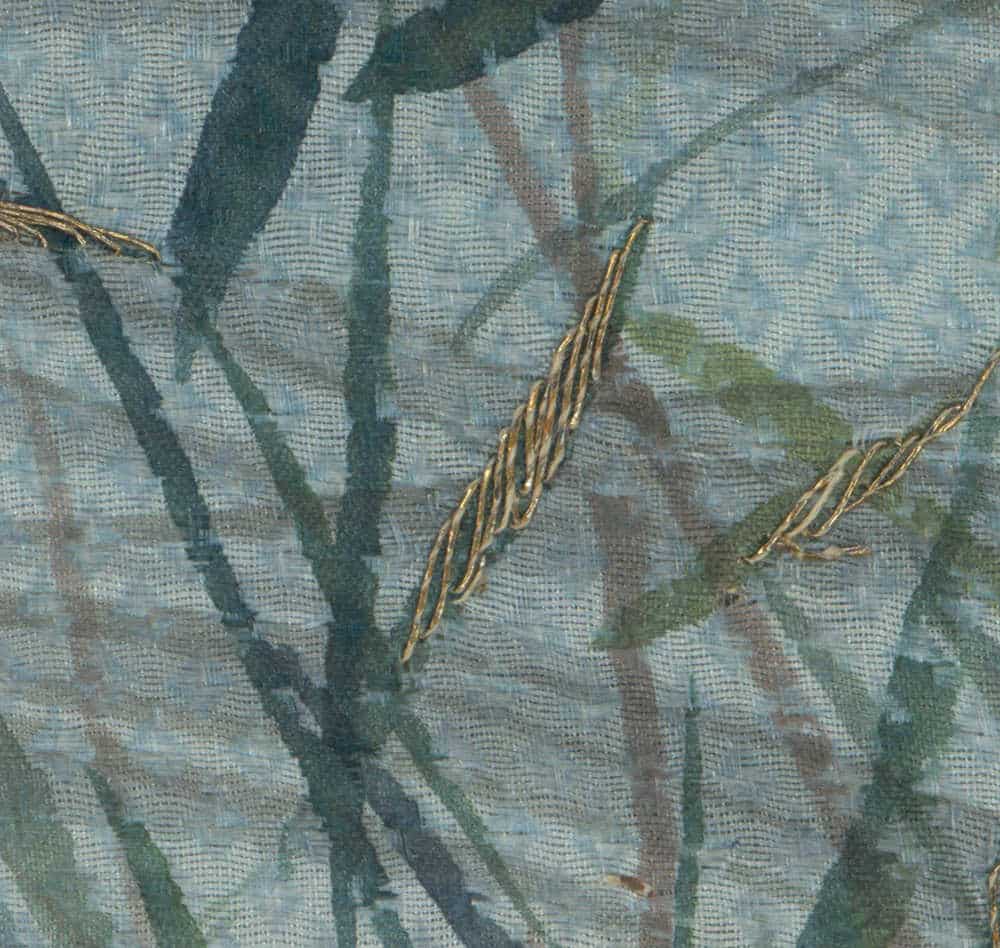 Textured fabric with blue-green branches and golden embroidered lines