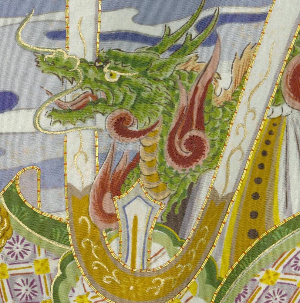 Green Chinese dragon with golden details on decorative fabric background