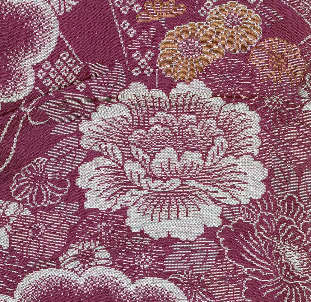 Burgundy and white floral textile with intricate woven flower pattern