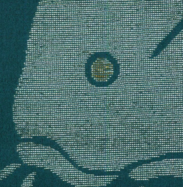 Green woven textile with textured pattern and circular center detail
