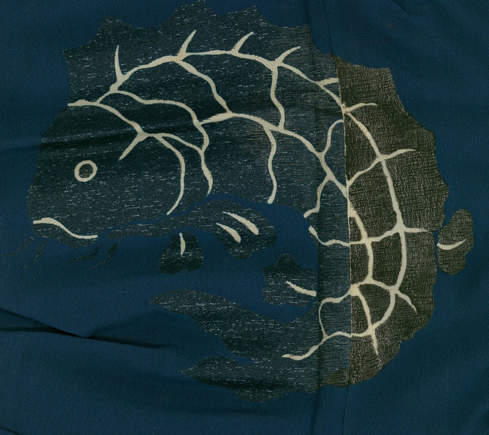 Stylized fish with cracked texture on dark blue textile background