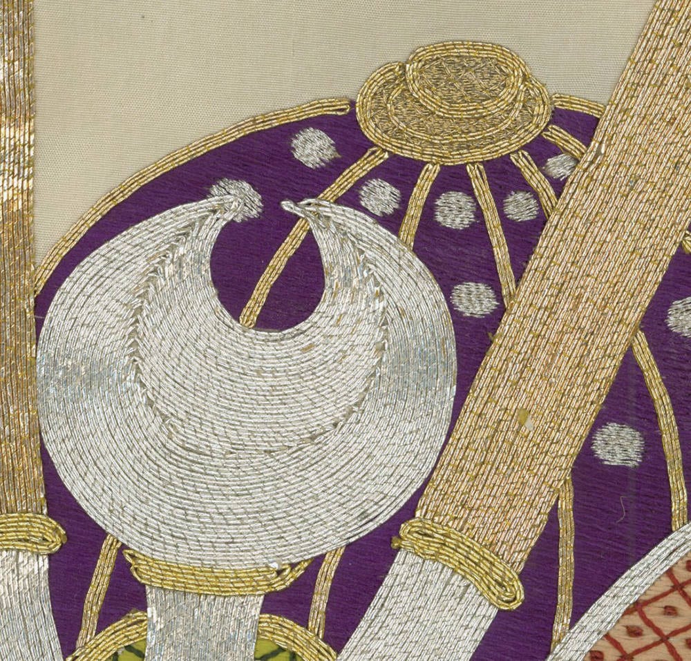 Intricate embroidery with silver and gold circular patterns on purple background