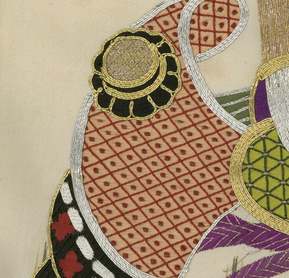 Intricate Japanese textile with embroidered geometric patterns and flower-like medallion