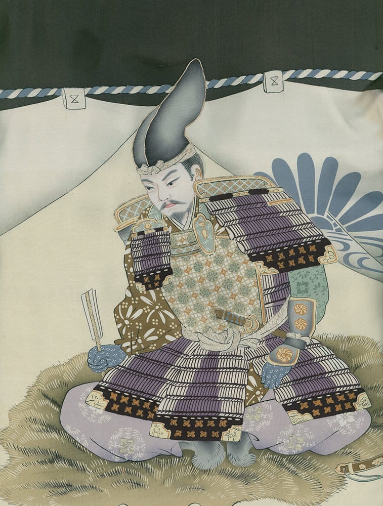 Japanese samurai in traditional armor sitting cross-legged on grass