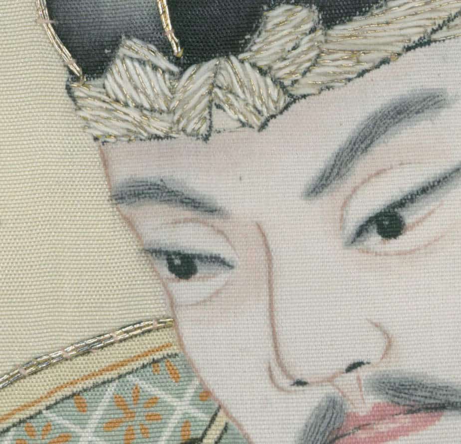 Embroidered portrait of a serene face with delicate textile details