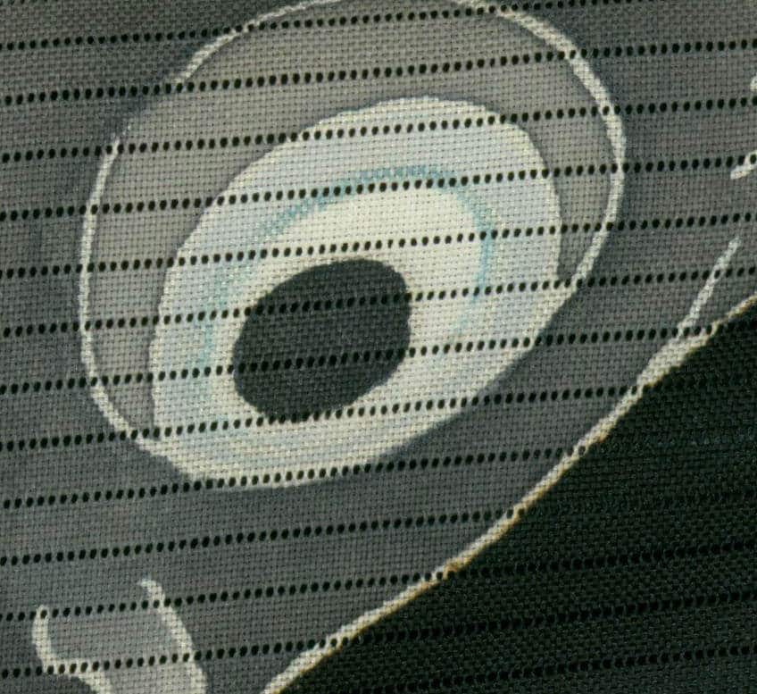 Dotted spiral pattern on textured fabric with grayscale color scheme