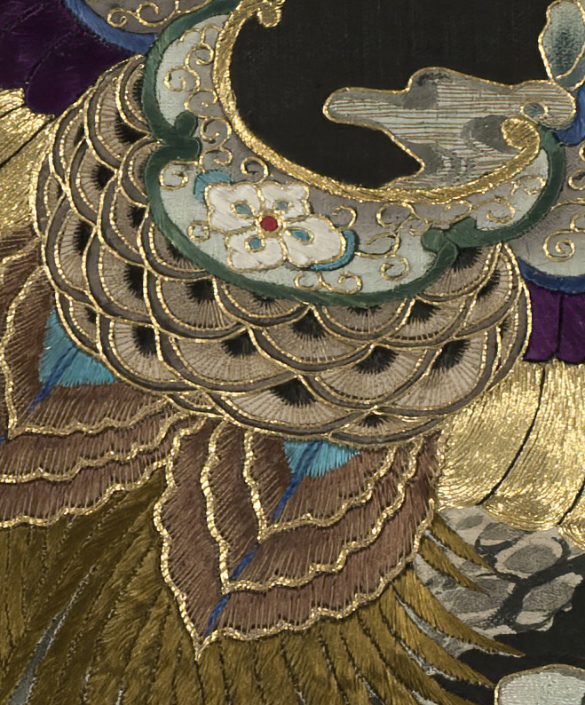 Intricate gold and colored embroidery with ornate floral and scalloped design