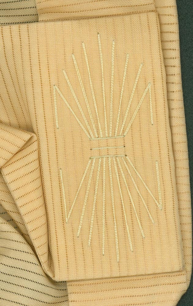 Beige textile with geometric sunburst embroidery in light thread