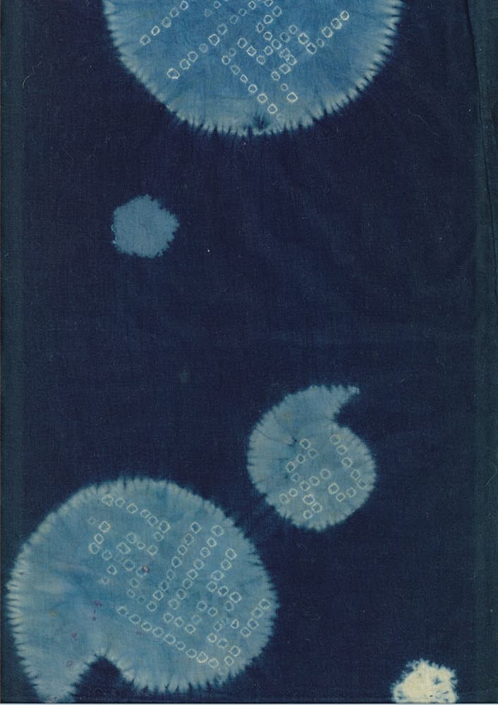 Blue and indigo shibori tie-dye fabric with circular pattern