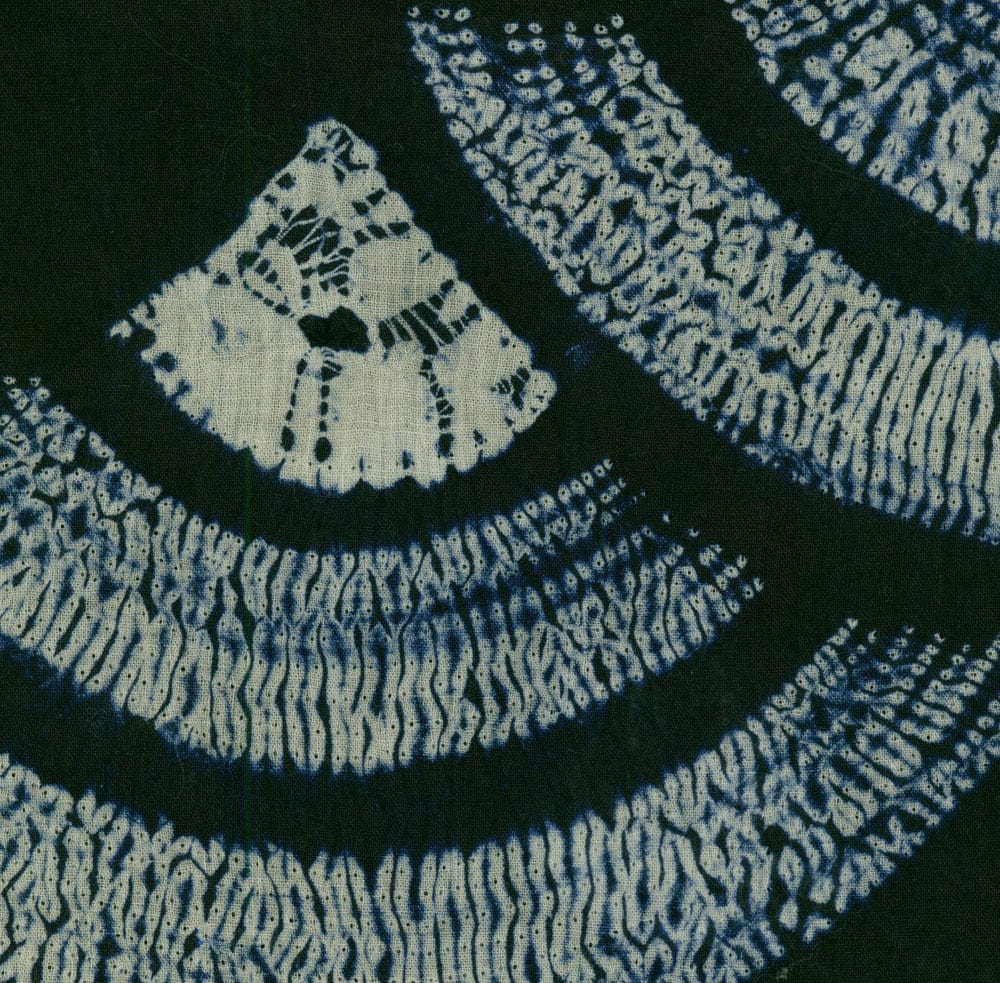 Blue and white shibori fabric with curved geometric patterns