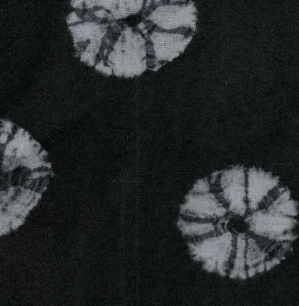 Black and white tie-dye fabric with circular white patterns
