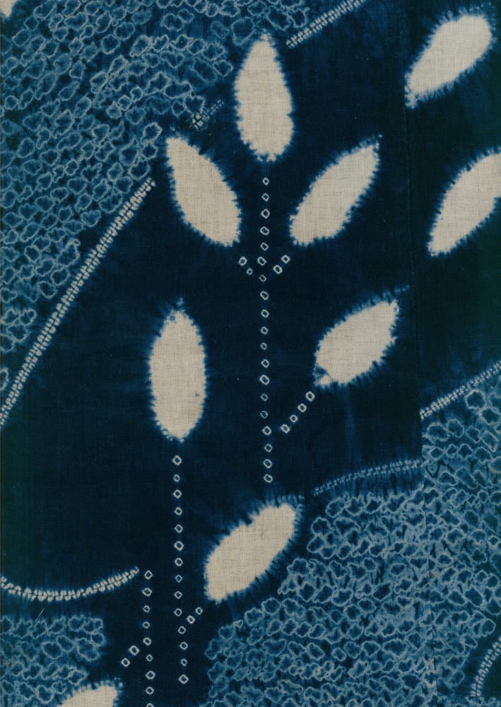 Blue and white shibori fabric with leaf-like pattern and intricate texture