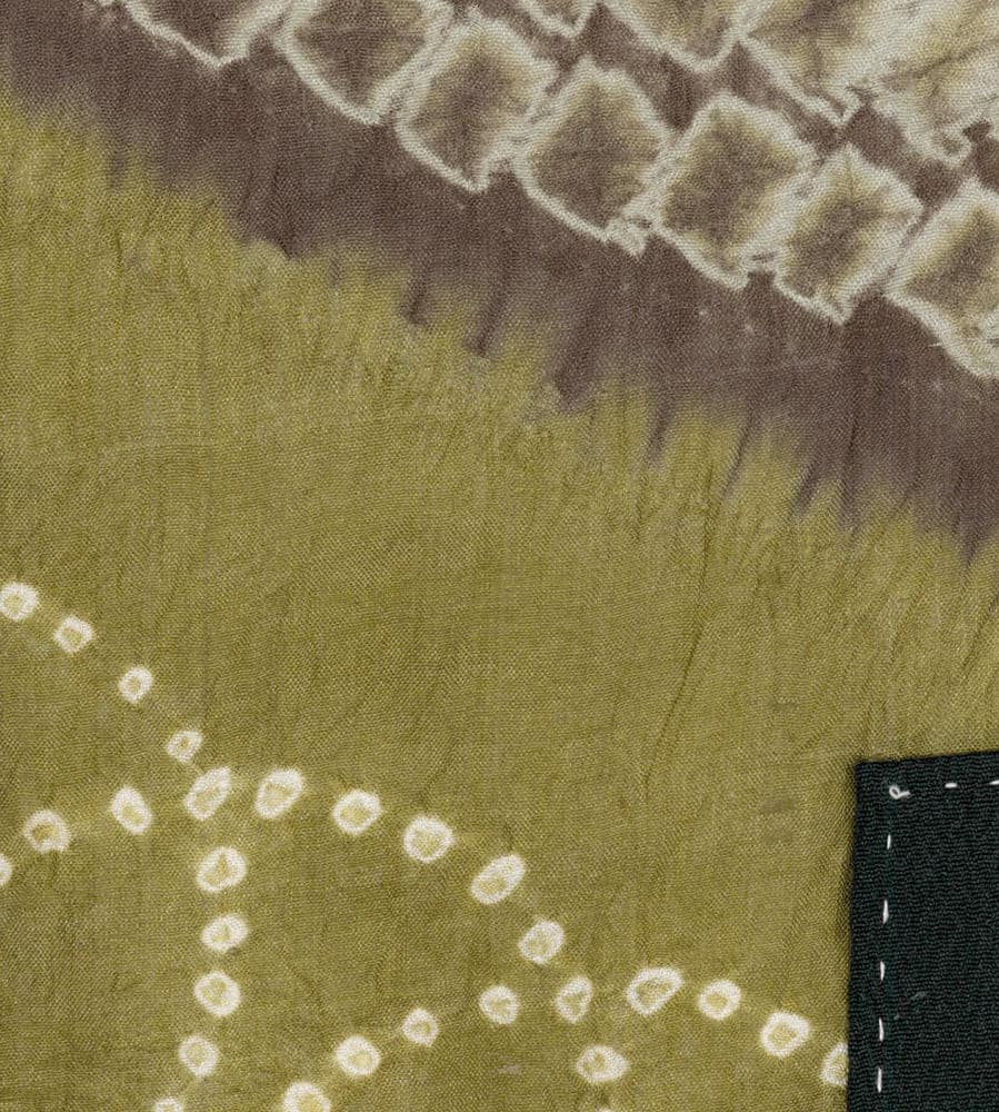 Olive green fabric with tie-dye pattern and white circular dot design