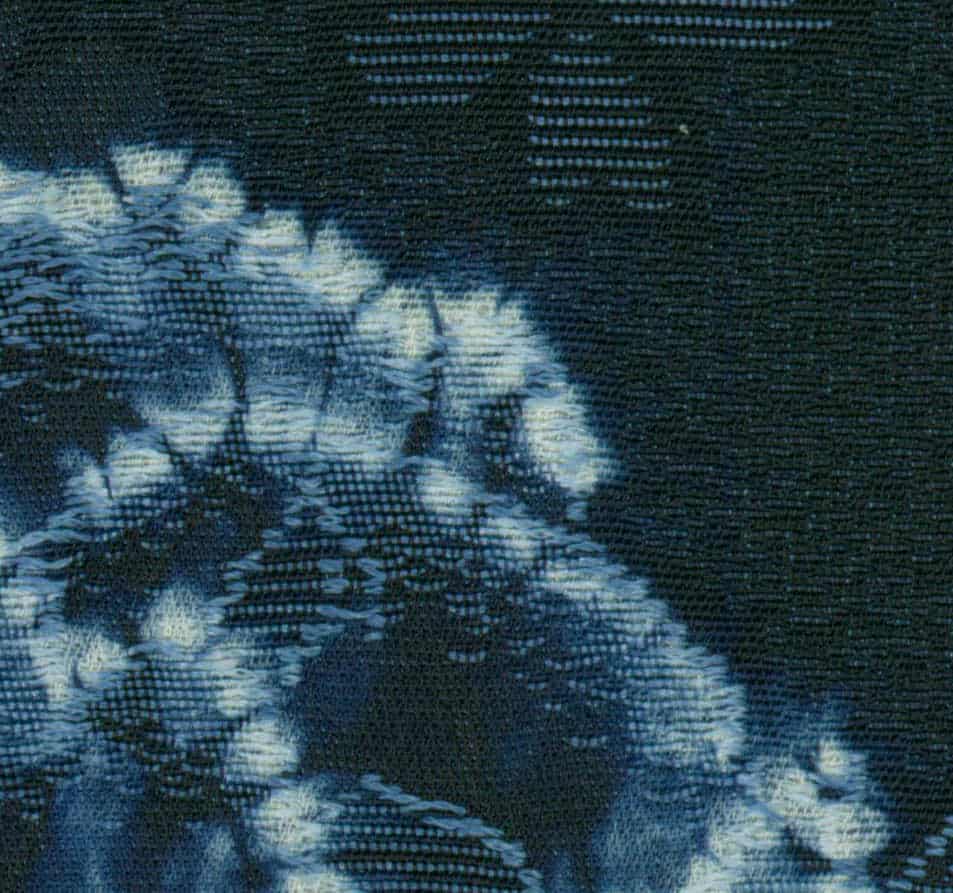 Blurry blue and white tie-dye textile with textured pixelated pattern