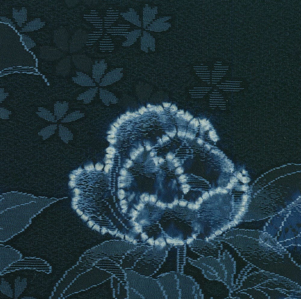 Blue and white shibori-style fabric with floral pattern and rose design