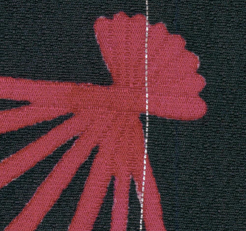 Red flower-like shape with textured fabric on black background